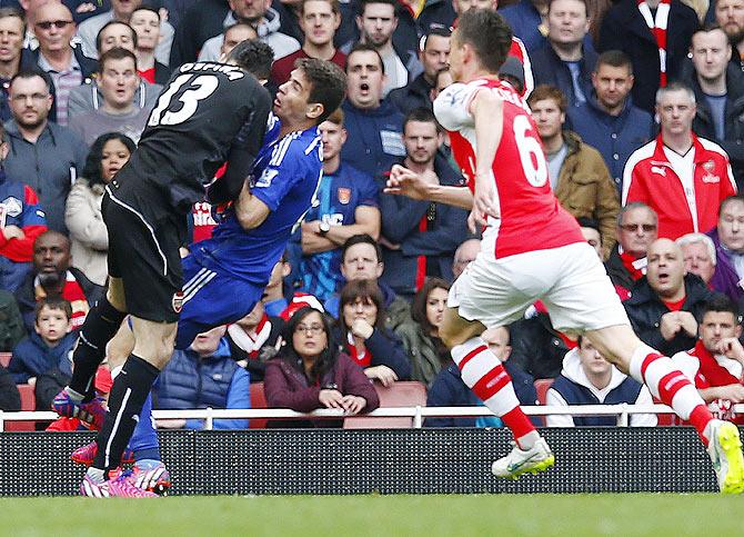 Chelsea's Oscar collides with Arsenal's David Ospina after shooting at goal during their English Premier League match on Sunday