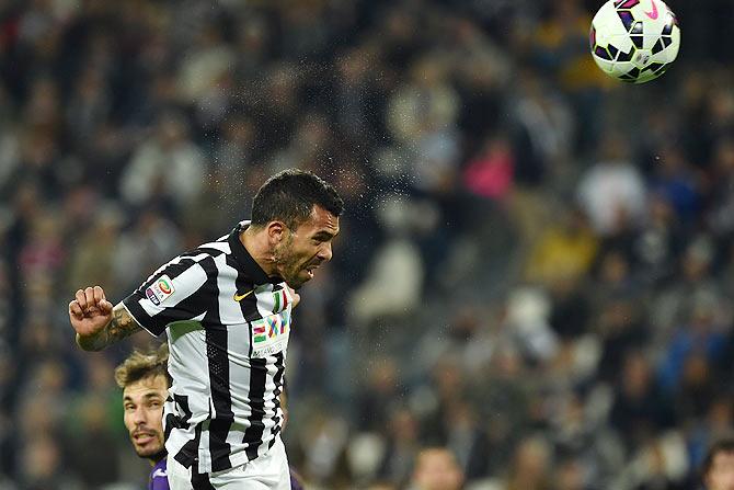 Carlos Tevez of Juventus FC heads to score during their Serie A match against ACF Fiorentina at Juventus Arena in Turin on Wednesday