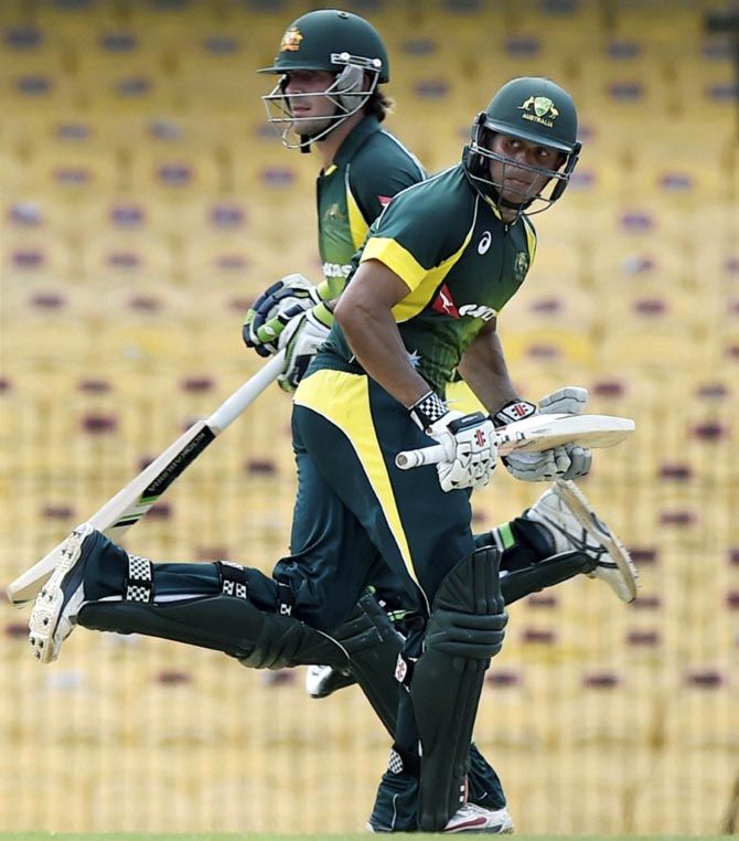 Joe Burns (left) and Usman Khawaja run between the wickets
