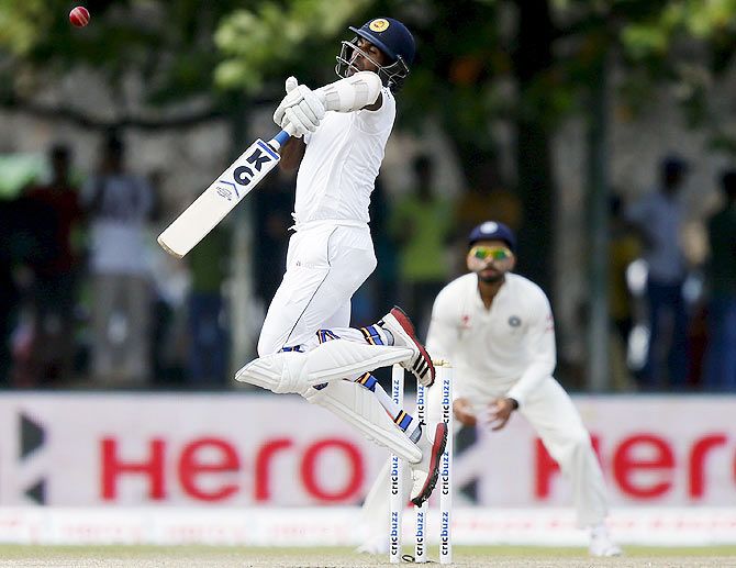 Sri Lanka's Dhammika Prasad gets an awkward bounce and was caught out by India's Ajinkya Rahane as India's captain Virat Kohli looks on Day 3 of the first Test match in Galle on Friday