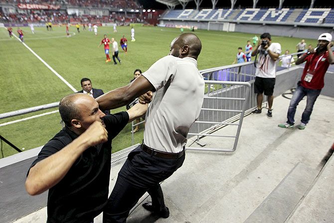 Costa Rica coach Paulo Wanchope (right) fights with a security guard during the Olympic qualifying match between Costa Rica amd Panama at the Maracana stadium in Panama City on Tuesday, August 11