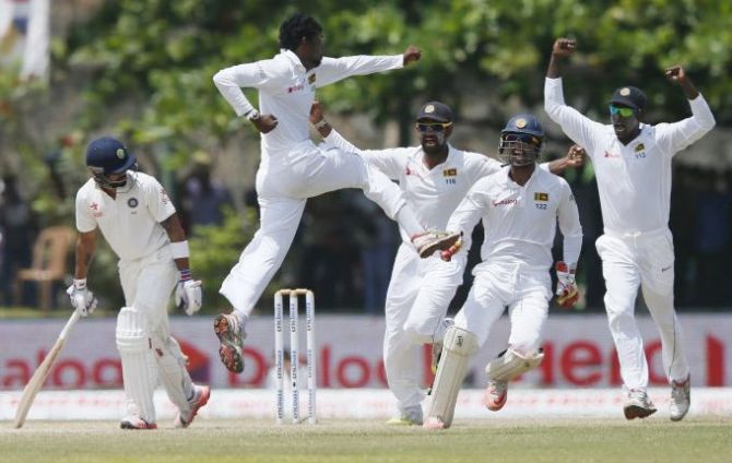 Sri Lanka's Tharindu Kaushal (second from left) celebrates with his teammates after taking the wicket of India's Virat Kohli (left) during Day 4 of the first Test match in Galle on Saturday, August 15