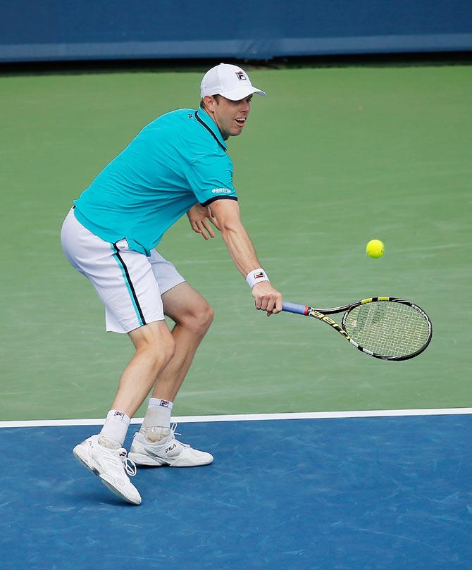 USA's Sam Querrey returns a shot to compatriot John Isner