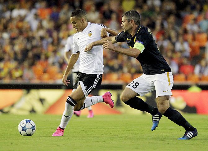 Valencia's Rodrigo (left) controls the ball past Monaco's Jeremy Toulalan during their Champions League play-off first leg soccer match at the Mestalla stadium in Valencia on Wednesday