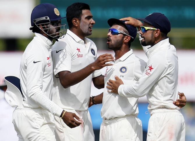 Ravichandran Ashwin (2nd left) celebrates the wicket of Kumar Sangakkara with teammates. 