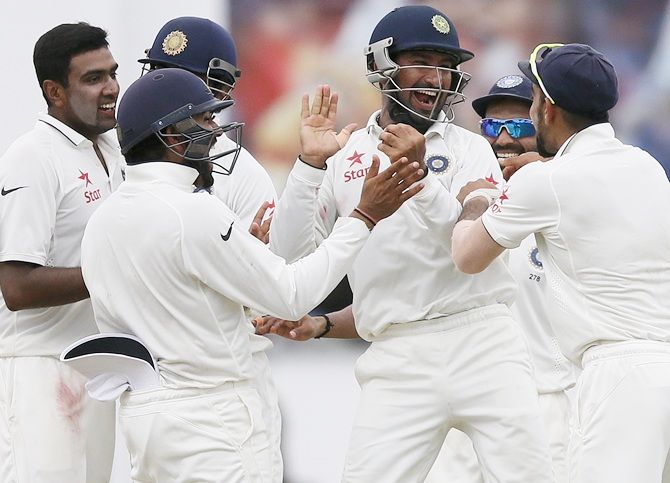 India's Cheteshwar Pujara, centre, celebrates with captain Virat Kohli