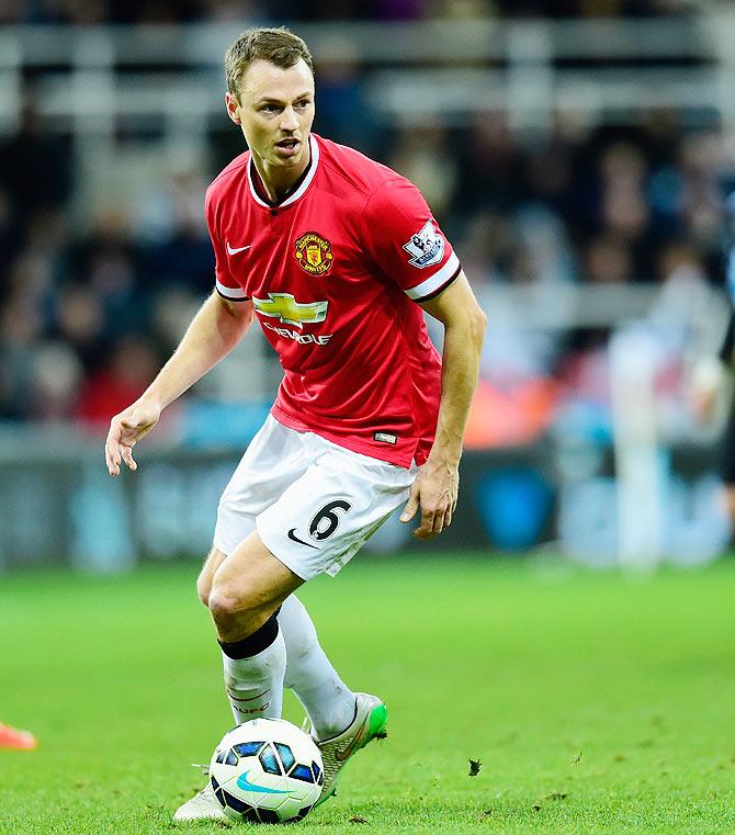 Manchester United player Jonny Evans (left) in action