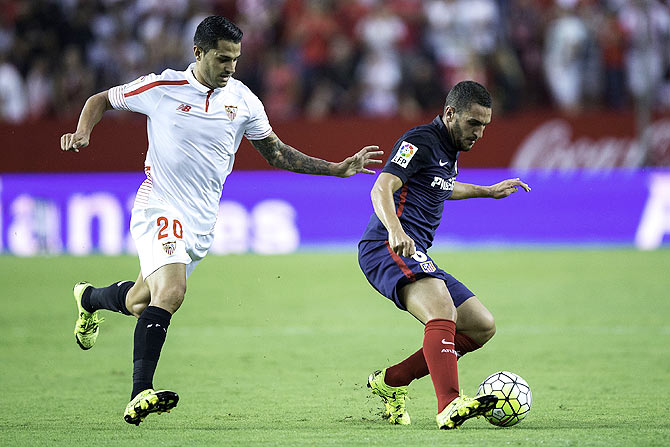 Atletico de Madrid's Koke (right) competes for the ball with Sevilla FC's Vctor Machin alias Vitolo (left)