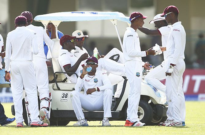 Players of the West Indies cricket team take a drinks break during a Test match against Australia