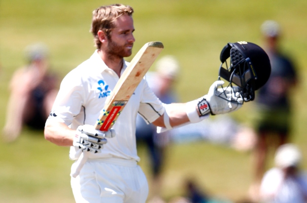 Kane Williamson of New Zealand raises his bat after completing his century 