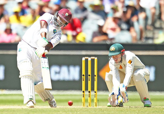 West Indies' Darren Bravo hits a boundary as Australia's wicketkeeper Peter Nevill looks on, on day three of the second Test match at the Melbourne Cricket Ground on Monday
