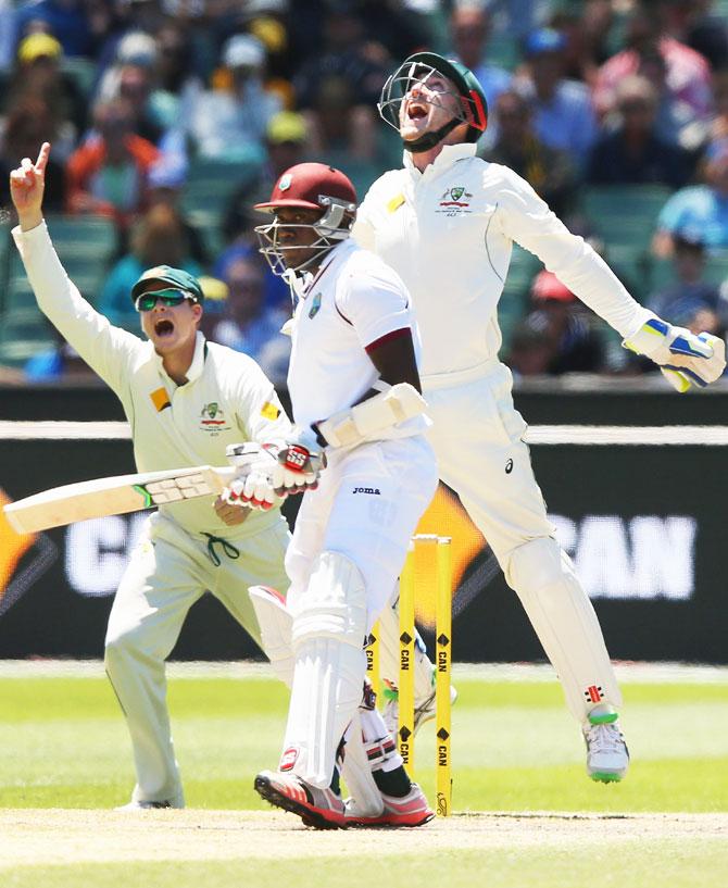 Australia's Peter Nevill celebrates with Steve Smith (left) after catching out West Indies's Jerome Taylor off the bowling of Nathan Lyon