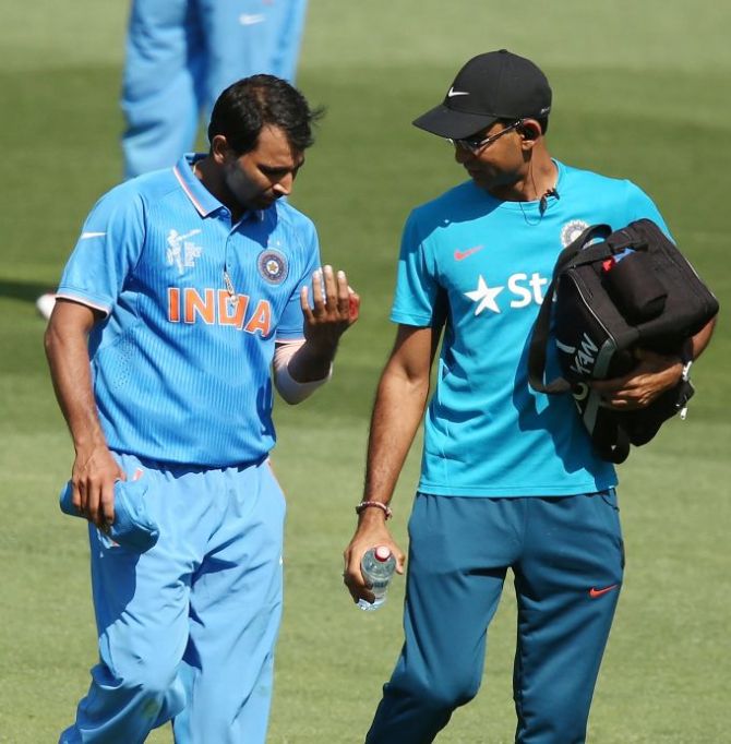 Mohammed Shami, left, of India leaves the field to receive treatment after injuring his left hand