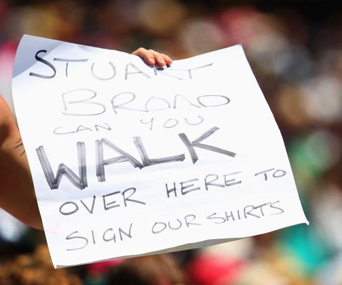 A member of the crowd holds a sign