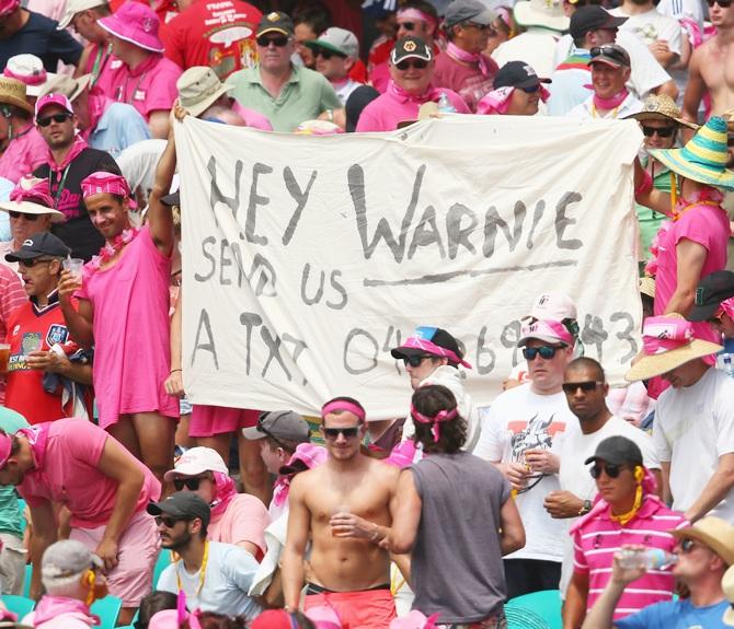 Members of the crowd hold up a sign