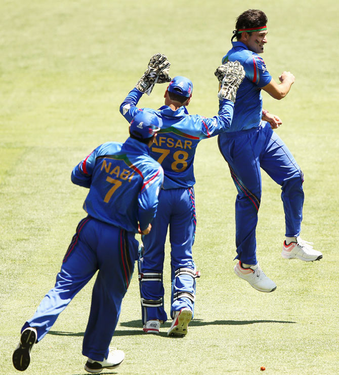 Hamid Hassan of Afghanistan celebtrates after bowling out Shikhar Dhawan of India during their 2015 ICC Cricket World Cup warm up match at Adelaide Oval on Tuesday