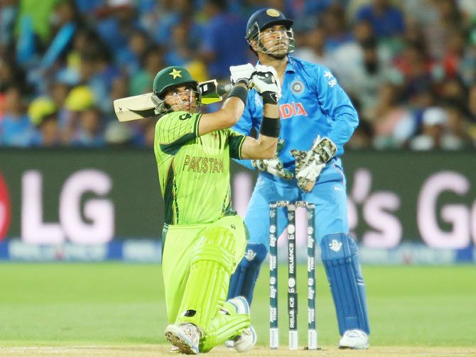 Misbah-ul-Haq of Pakistan hits a boundary as India's wicketkeeper and captain Mahendra Singh Dhoni looks on
