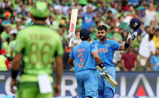 India's Virat Kohli celebrates with teamate Suresh Raina after completing his century against Pakistan on Sunday