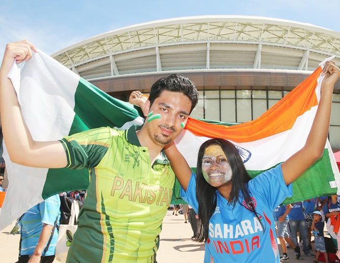 Pakistan and India supporters pose with their flags outside of the ground