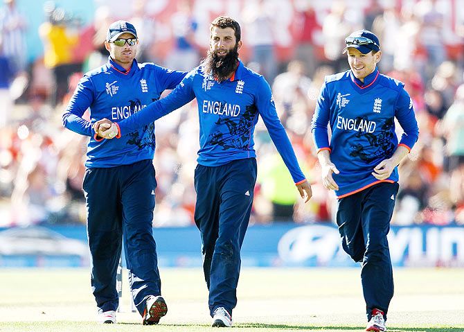 Moeen Ali celebrates with teammates Ian Bell (left) and Eoin Morgan after dismissing Kyle Coetzer of Scotland
