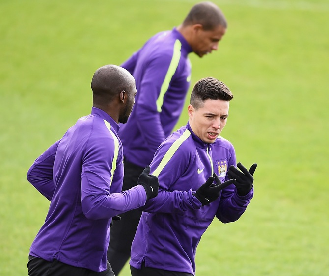 Eliaquim Mangala and Samir Nasri of Manchester City run during a Manchester City training session