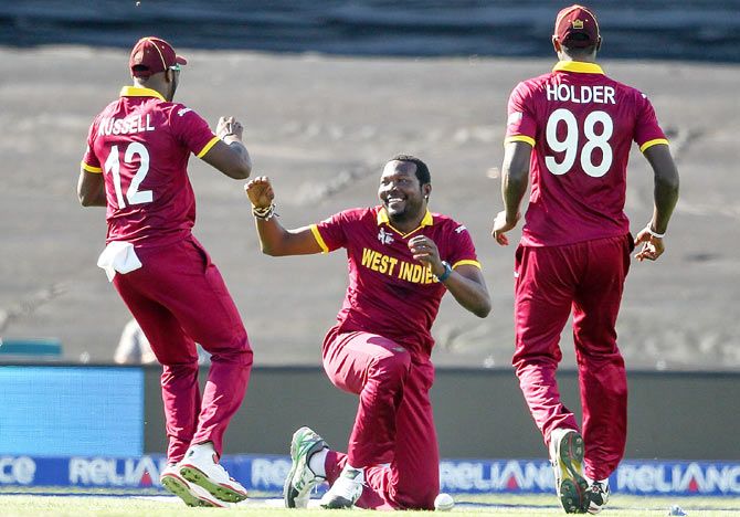 Sulieman Benn (centre) celebrates with teammates Andre Russell (left) and Jason Holder (right)