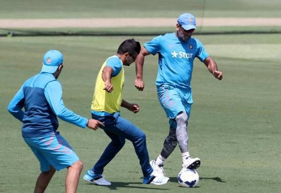 Mahendra Singh Dhoni (right) plays football