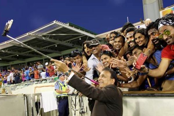 Former Indian cricketer Sunil Gavaskar takes a selfie with Indian fans 