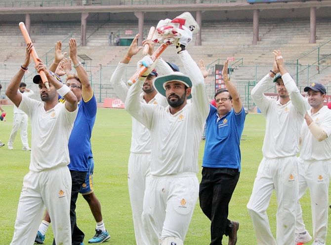 Karnataka's R Vinay Kumar, left and Robin Uthappa, centre, celebrate win against Mumbai