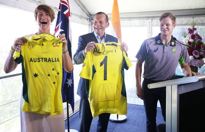 Australian Prime Minister, Tony Abbott and his wife Margaret hold up personalised Australian One-day jerseys given by Australian captain, Steve Smith on Thursday