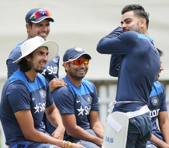 Virat Kohli speaks to his teammates during a training session