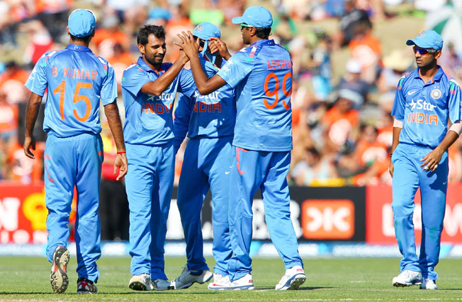 Mohammed Shami of India is congratulated by Ravichandran Ashwin after taking a catch off his own bowling to dismiss Nathan McCullum of New Zealand
