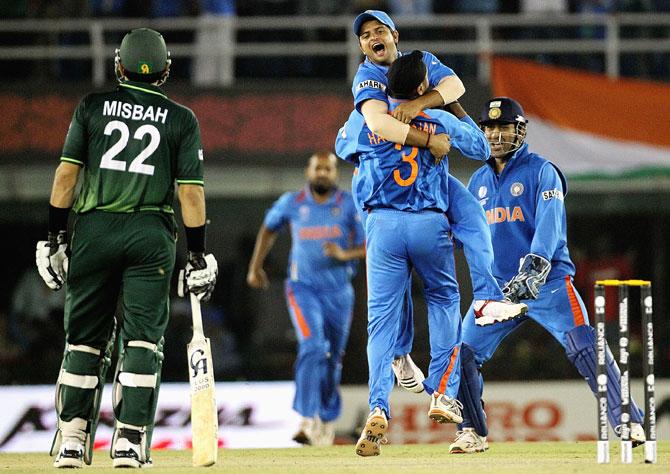 Suresh Raina of India leaps into the arms of team mate Harbhajan Singh with MS Dhoni (right) ad Misbah-ul-Haq of Pakistan looking on during the 2011 World Cup semi-final in Mohali.