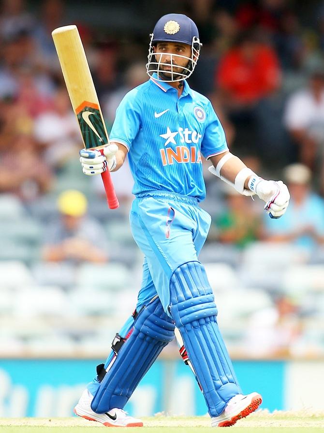 Ajinkya Rahane of India raises his bat to celebrate his half century