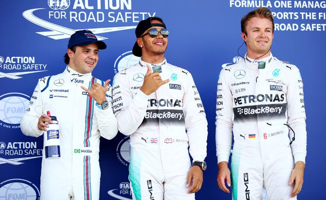 Lewis Hamilton of Mercedes GP celebrates in Parc Ferme next to teammate Nico Rosberg and Felipe Massa of Williams after claiming pole position during qualifying for the Formula One Grand Prix of Great Britain at Silverstone Circuit in Northampton, on Saturday