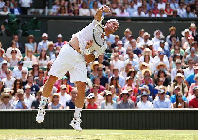 Australia's Sam Groth serves to Switzerland's Roger Federer during their third round match on Saturday