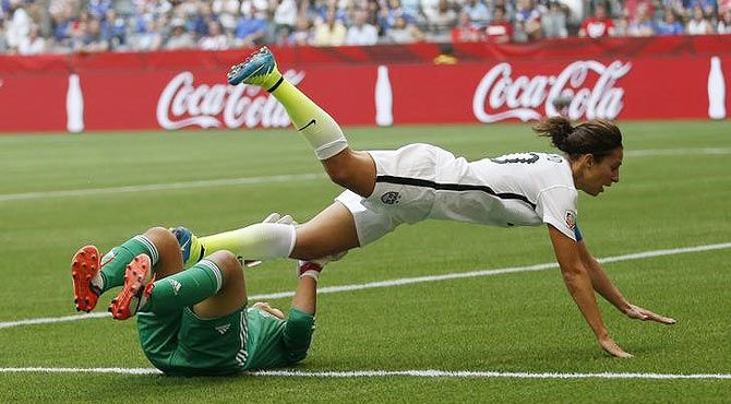 United States midfielder Carli Lloyd (10) collides with Japan goalkeeper Ayumi Kaihori (18) 