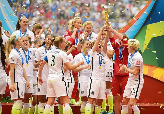 United States players celebrate as they receive the FIFA Women's World Cup trophy after defeating Japan in the final of the FIFA 2015 Women's World Cup at BC Place Stadium in Vancouver on Sunday