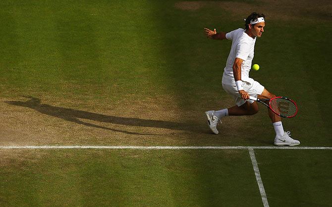 Roger Federer plays a backhand against Andy Murray