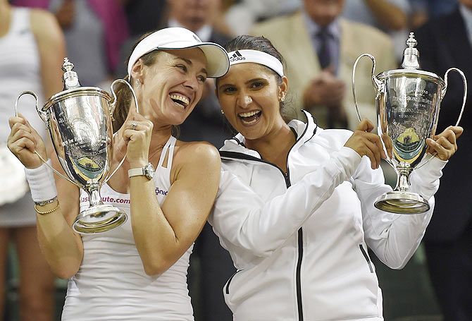 Switzerland's Martina Hingis and India's Sania Mirza pose after winning their women's doubles final against Russian duo Elena Vesnina and Ekaterina Makarova at the Wimbledon Tennis Championships in London on July 11