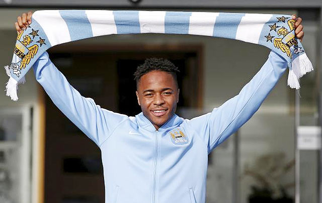 New Manchester City signing Raheem Sterling poses with a club scarf as he leaves the club's Etihad Stadium in Manchester on Tuesday