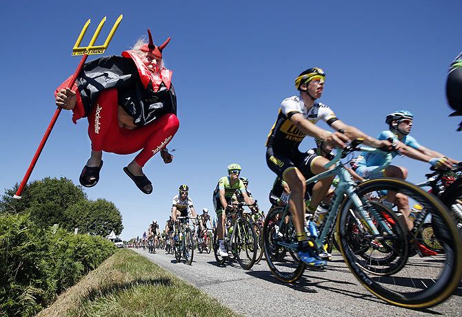 A pack of riders makes its way past Didi Senft, a cycling enthusiast better known as 'El Diablo' (The Devil), during the 190.5-km (118.4 miles) 7th stage of the 102nd Tour de France cycling race from Livarot to Fougeres, France, on July 10