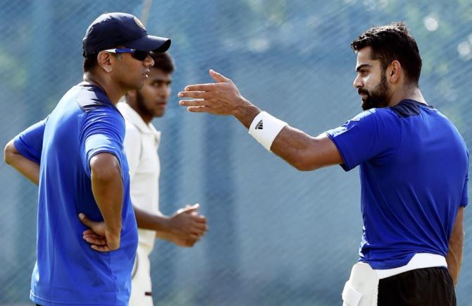Virat Kohli (right) speaks to India 'A' coach Rahul Dravid