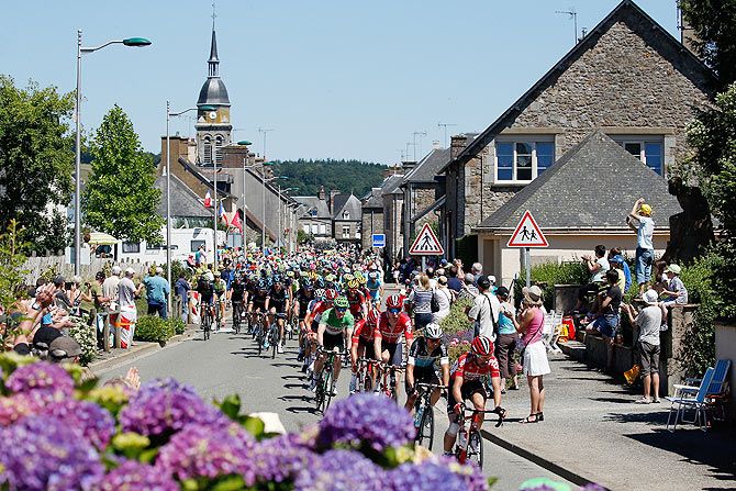 The peloton passes down the Rue de la Liberation during stage seven from Livarot to Fougeres on July 10