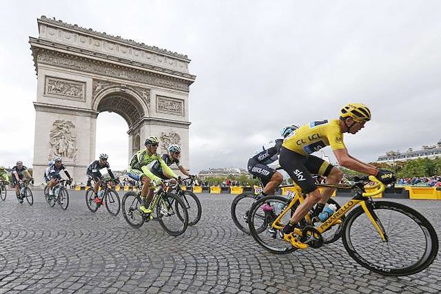 Team Sky rider Chris Froome of Britain (right), the race leader's yellow jersey, cycles near the Arc de Triomphe during the 109.5-km (68 miles) final 21st stage on Sunday