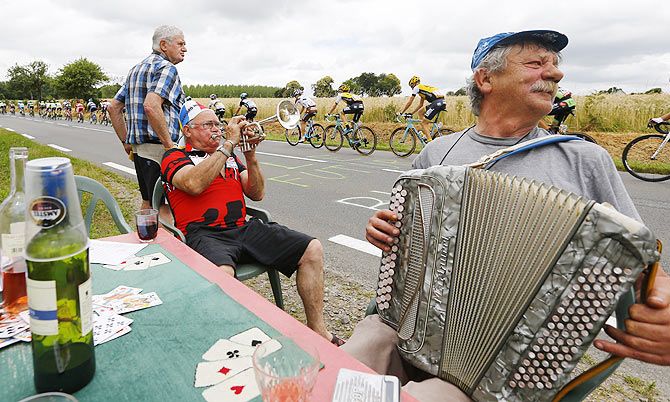 Cycling supporters play instruments as rider pass by during 8th stage from Rennes to Mur-de-Bretagne, France, on July 11