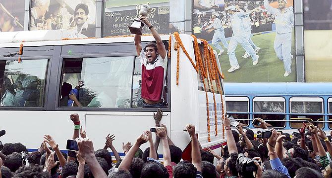 A Kolkata player celebrates with the I-League trophy