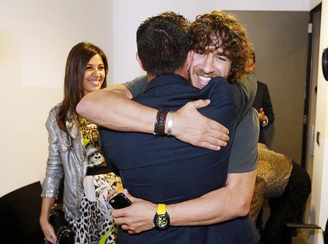 Xavi gets a hug from former teammate and captain Carles Puyol
