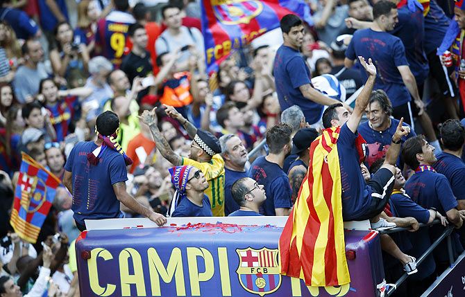 Barcelona's Xavi waves to supporters as he celebrates with teammates and staff members