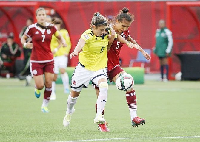 Mexico defender Valeria Miranda (5) and Colombia midfielder Daniela Montoya (6) battle for the ball during their Group F match at Moncton Stadium in New Brunswick